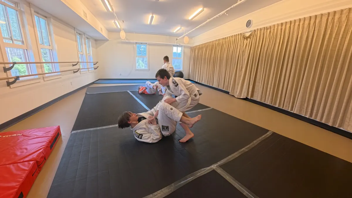 Coach-supervised partner work during a kids Brazilian Jiu Jitsu class in Tannersville NY