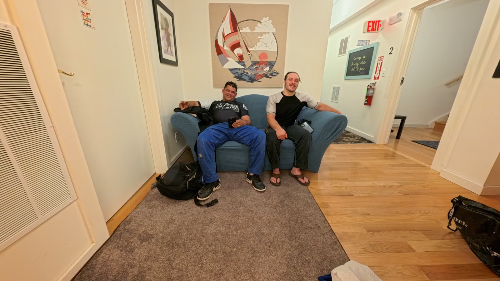 Two adult students relaxing in the waiting area outside the Sensei Sandy BJJ training room