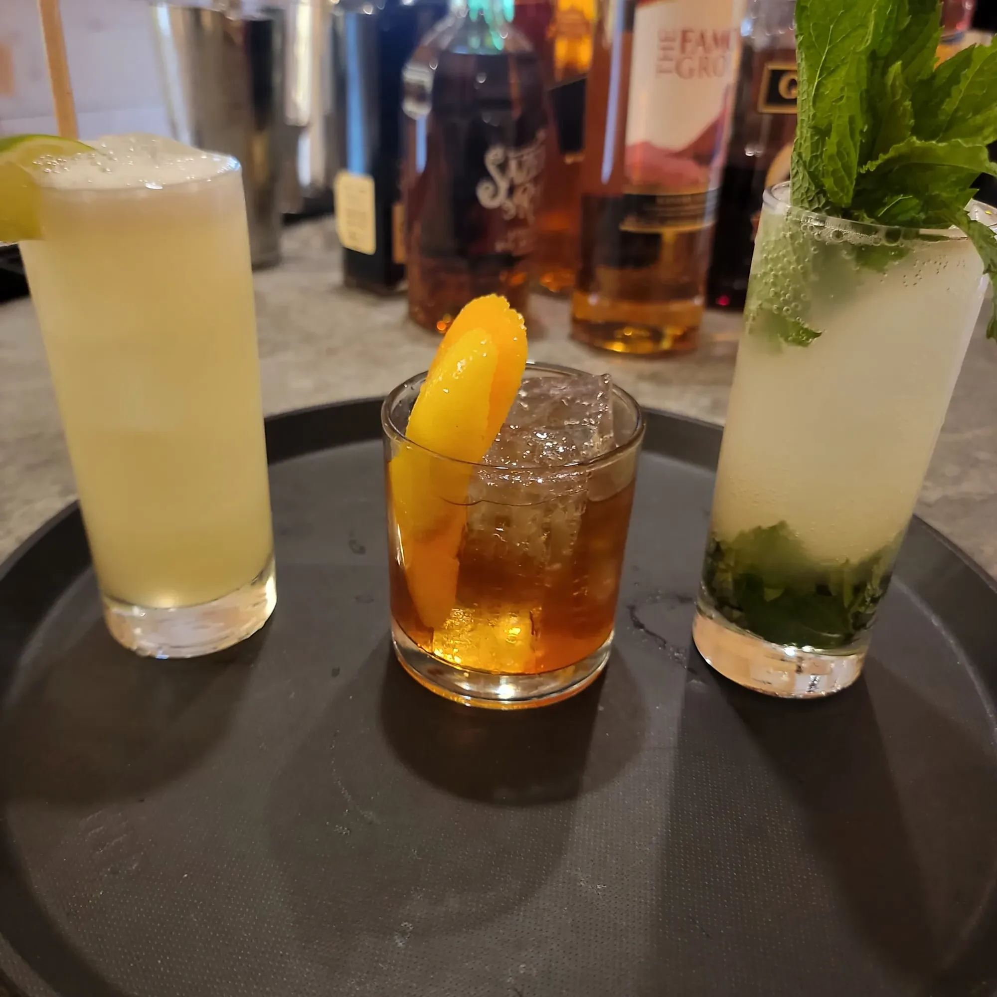 Three finished cocktails on a serving tray